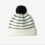 White-and-black striped knit beanie with fluffy black pom-pom and ribbed cuff