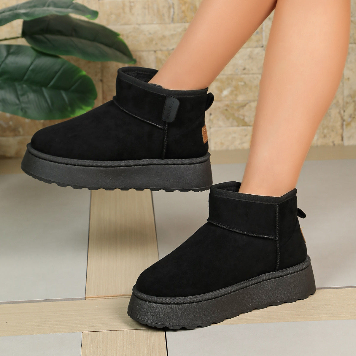 Women’s black short snow boots with ankle strap, thick sole, and soft fleece lining