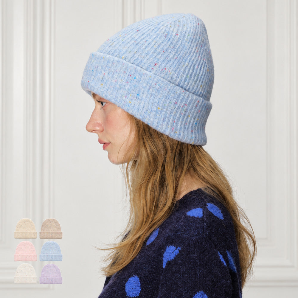 Light blue speckled rib-knit beanie with a folded cuff, shown in profile on a model.