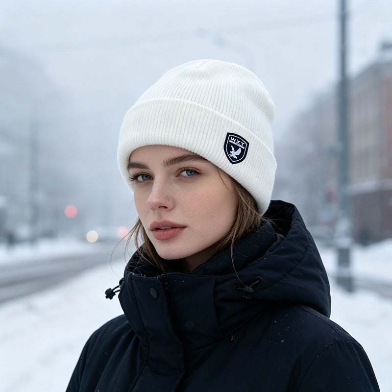 White ribbed knit beanie with fleece lining and logo patch