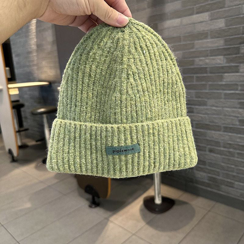Sage green ribbed knit beanie with wide cuff and woven "pipiswoot" label