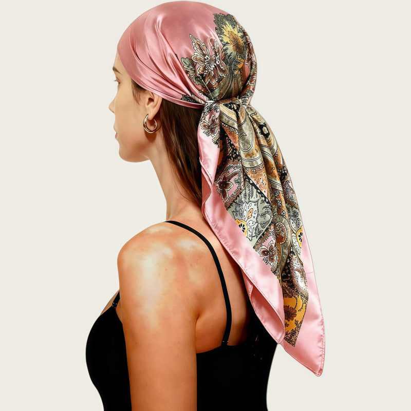 Satin head scarf in dusty pink with floral paisley print, tied at back.