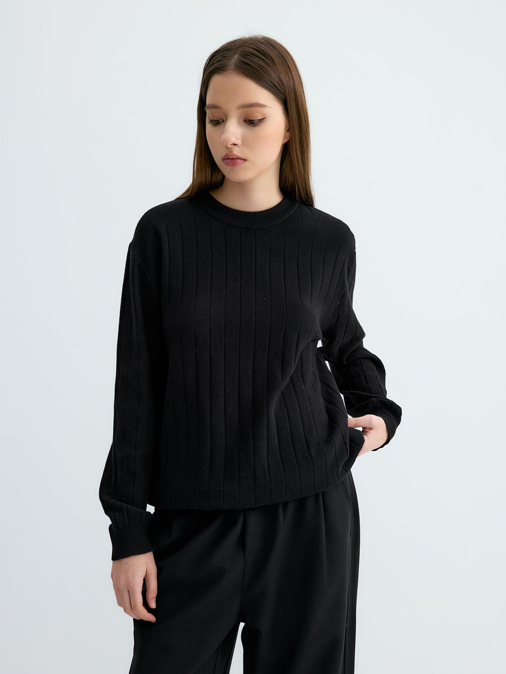 Black ribbed crew neck sweater with vertical knit stripes and banded cuffs