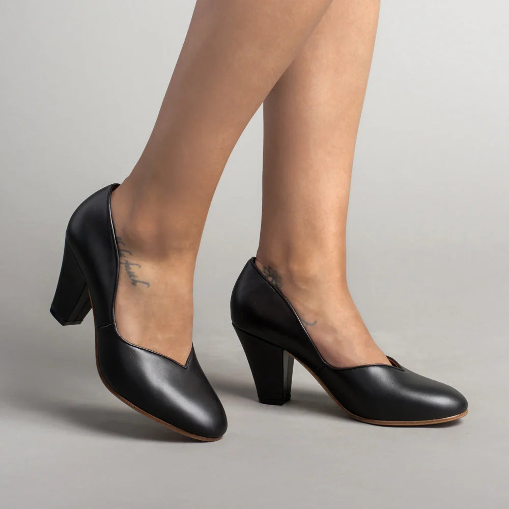 Black leather pumps with closed toes, V-cut openings, and block heels