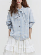 Light blue plaid button-up shirt with tie neck scarf and ruffled drawstring hem