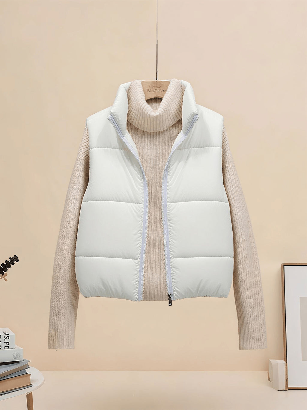 White sleeveless quilted puffer vest, stand collar zip front, cropped length.