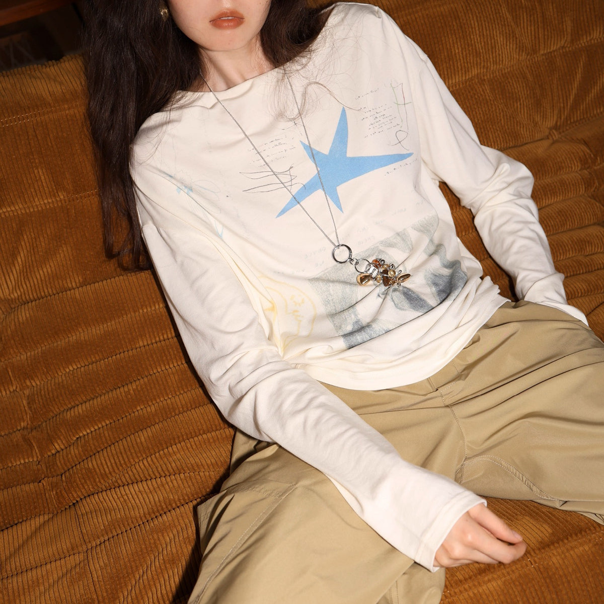 Cream long-sleeve graphic tee with blue star print and relaxed crew neckline