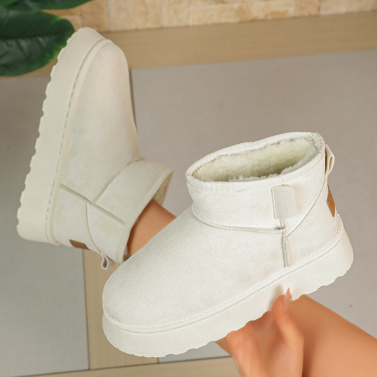Women’s white short snow boots with ankle strap and fleece-lined collar with thick sole