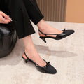 Black slingback kitten heel pumps with buckle strap and pointed cap toe