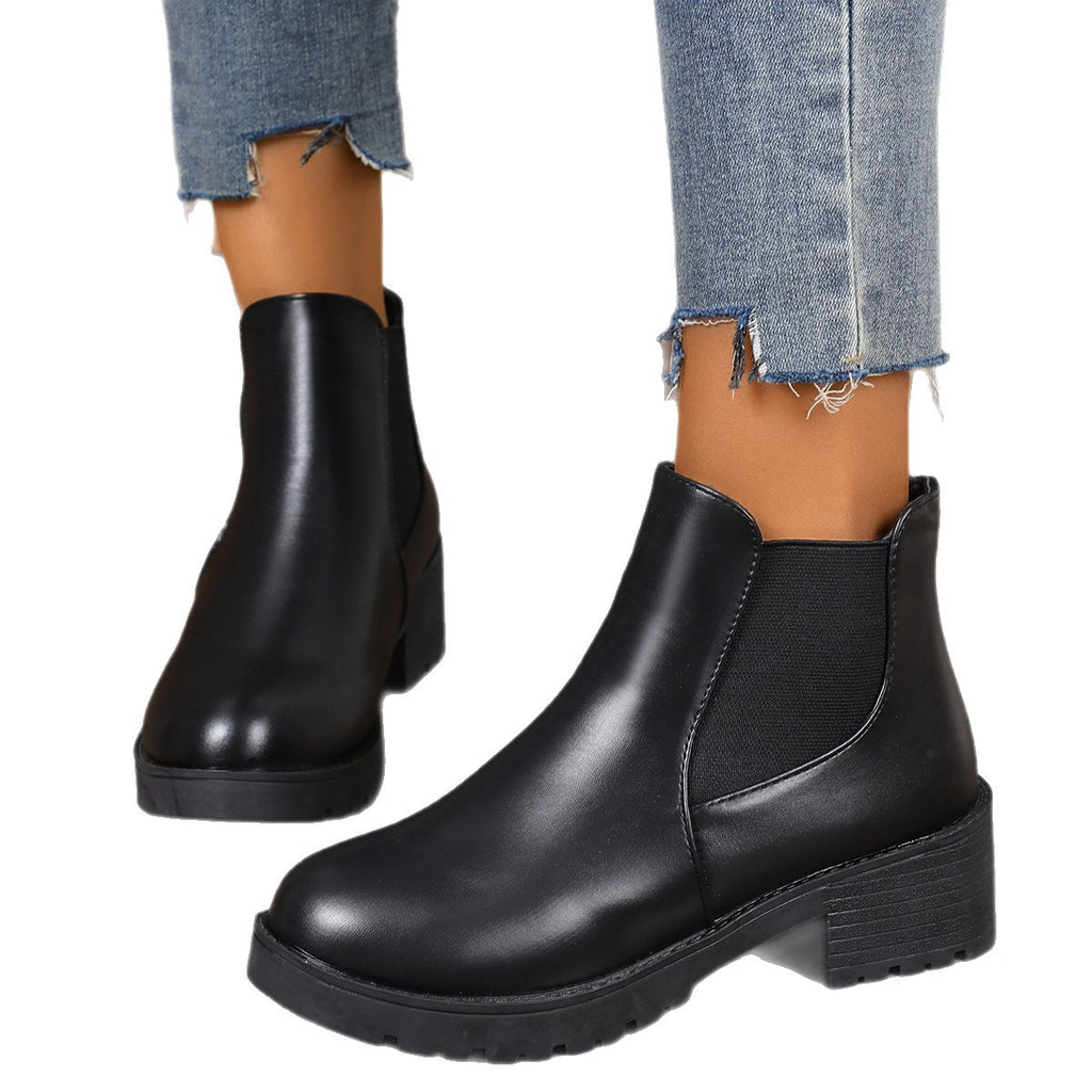 Women’s chunky Chelsea boots in black, front angle with elastic panels and lug sole.