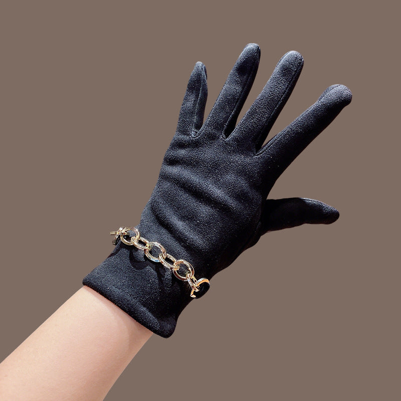 Black faux suede gloves with gold chain-link cuff, close-up wrist