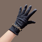 Black faux suede gloves with gold chain-link cuff, close-up wrist