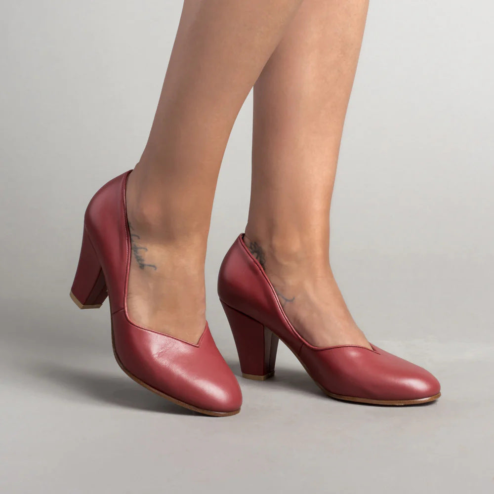 Red leather pumps with closed toes, V-cut openings, and block heels