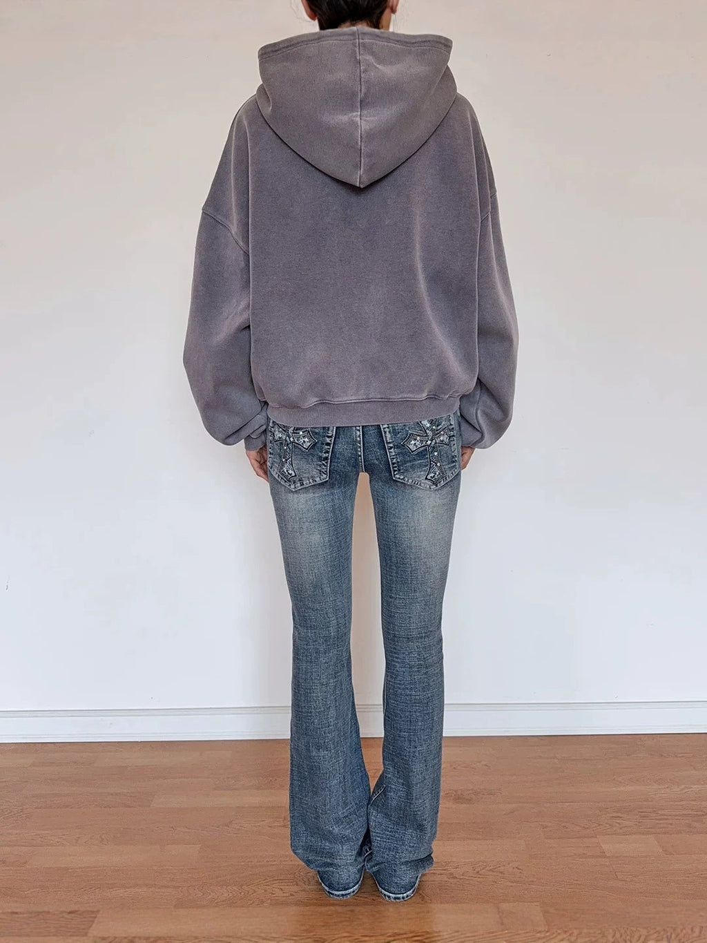 Back view of cropped gray zip-up hoodie with hood