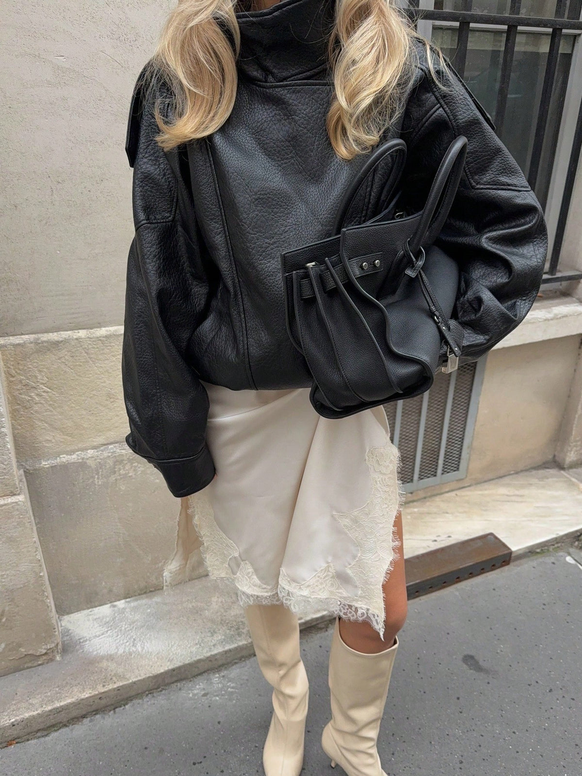 Black faux leather bomber jacket with stand collar and angled zip front