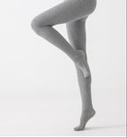 Light gray footed tights shown in a bent-leg pose