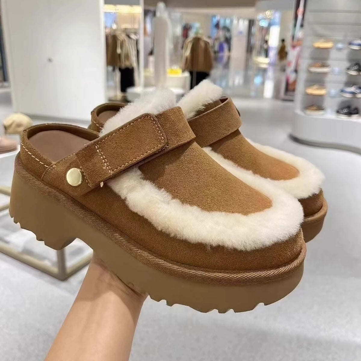 Camel-brown furry slip-on slippers with Velcro strap and thick lug sole.