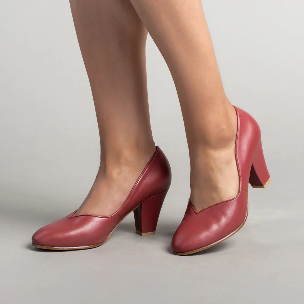 Red leather pumps in a three-quarter view, with closed toes and block heels