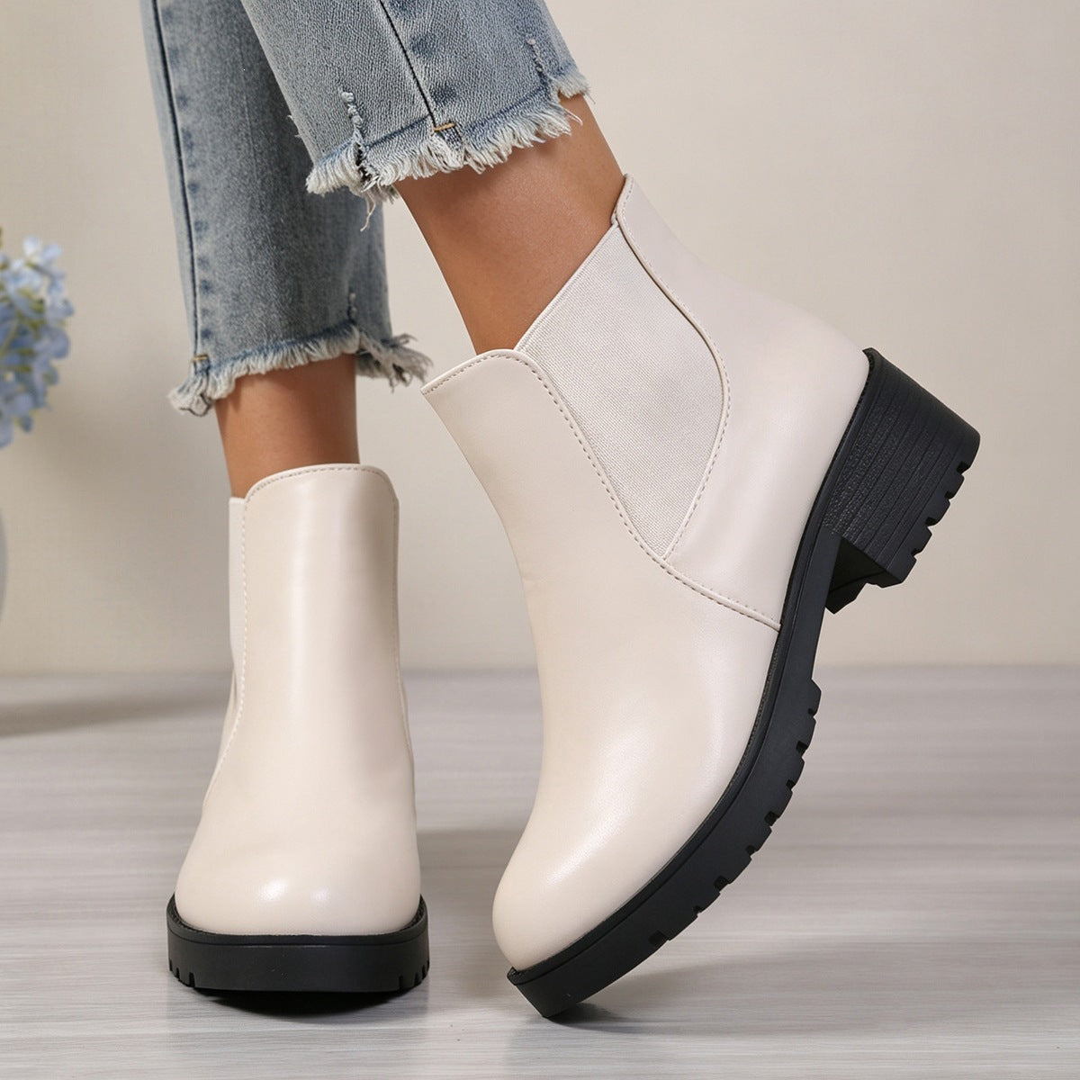 Women’s chunky Chelsea boots in off-white, side view with elastic panels and lug sole.