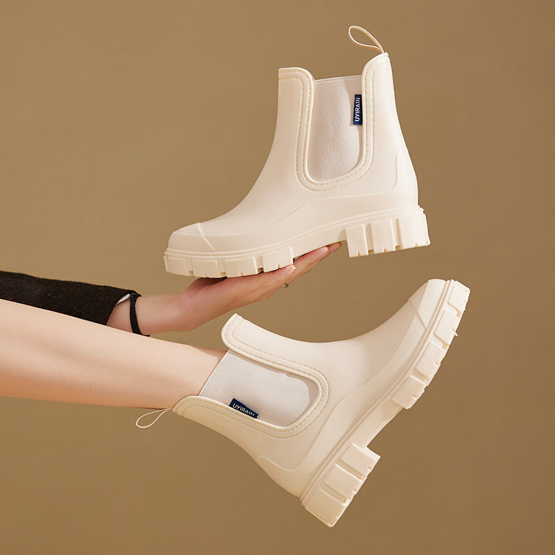 Chelsea rain boots in light cream matte rubber with chunky lug sole and pull tab.