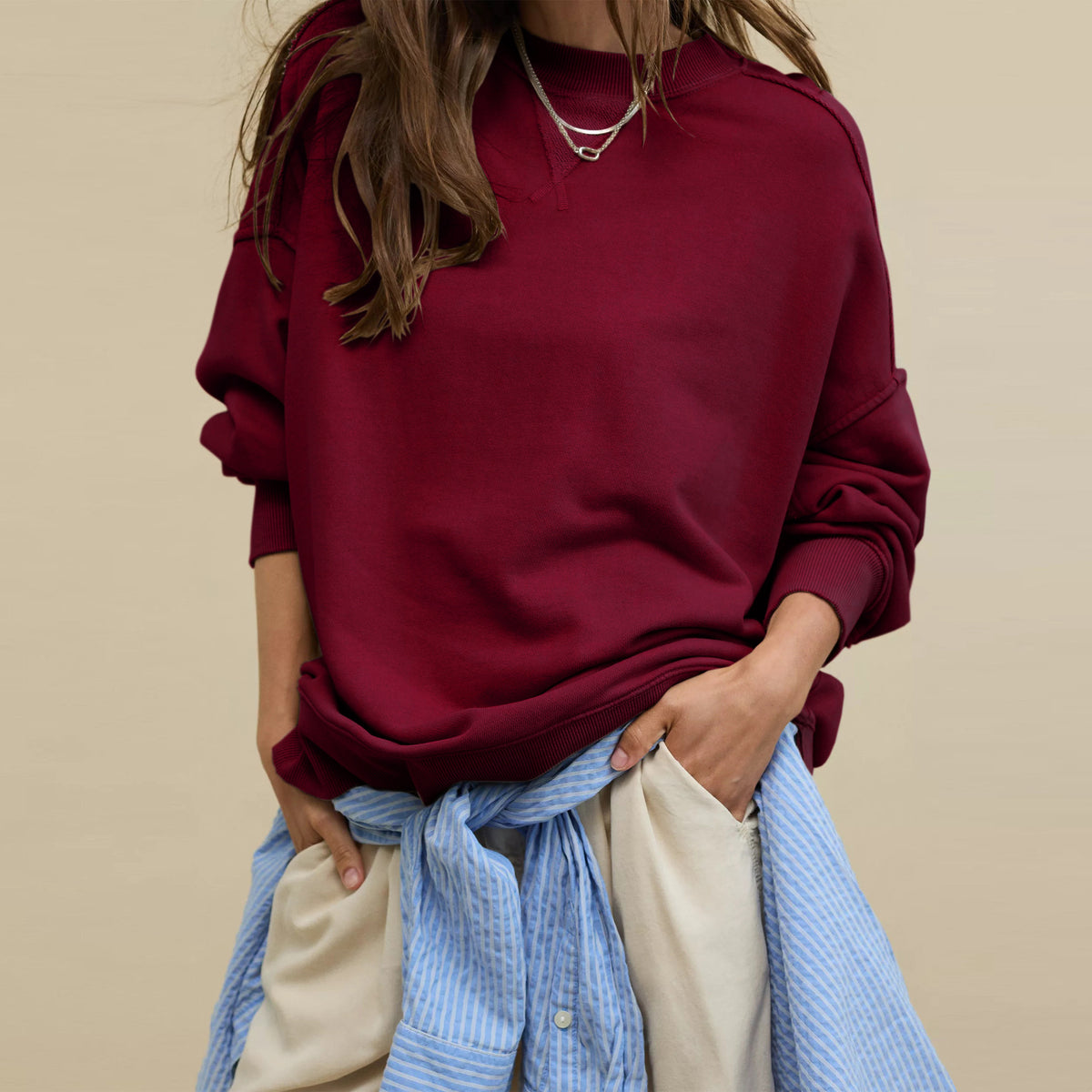 Oversized crewneck sweatshirt in burgundy with exposed seams and relaxed drop-shoulder