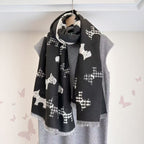 Black dog-print scarf with fringed ends, wrapped around a mannequin