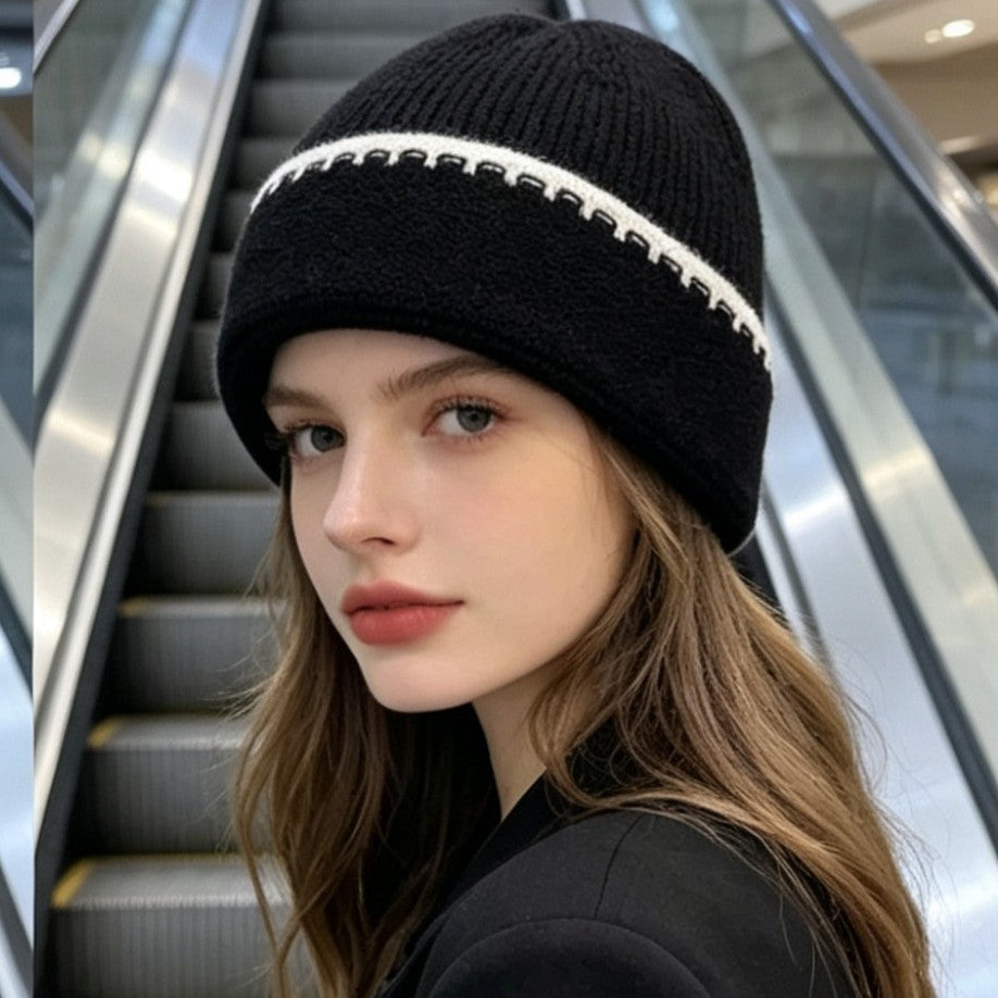 Ribbed knit beanie in black with white contrast stitch stripe at the cuff.