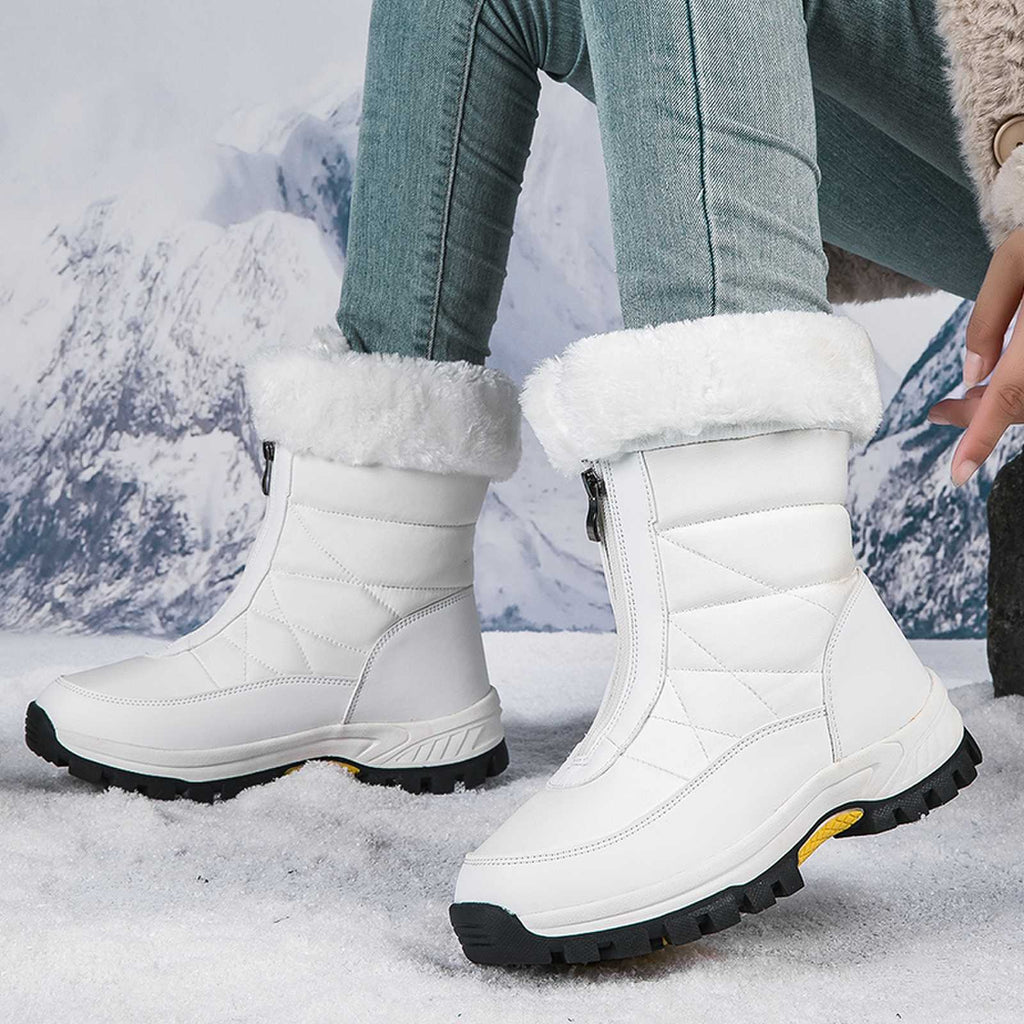 White mid-calf zip-up snow boots with faux fur lining and textured lug sole.