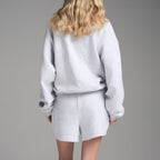 Light gray crew neck sweatshirt with matching drawstring shorts set, back view.