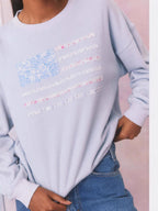 Light blue oversized crewneck sweatshirt with floral American flag stripes graphic