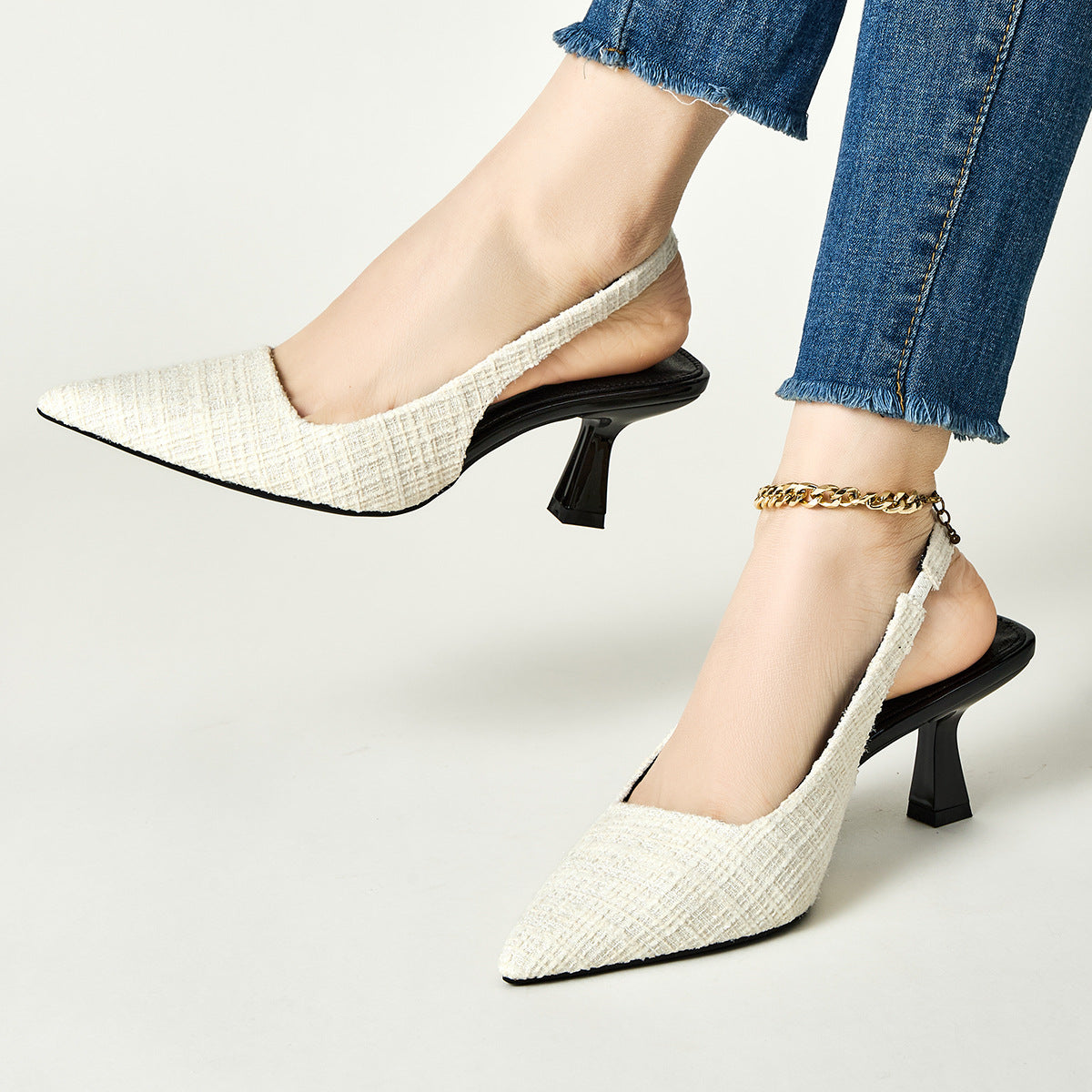 White tweed slingback pumps with pointed toe and flared heel, gold chain ankle strap
