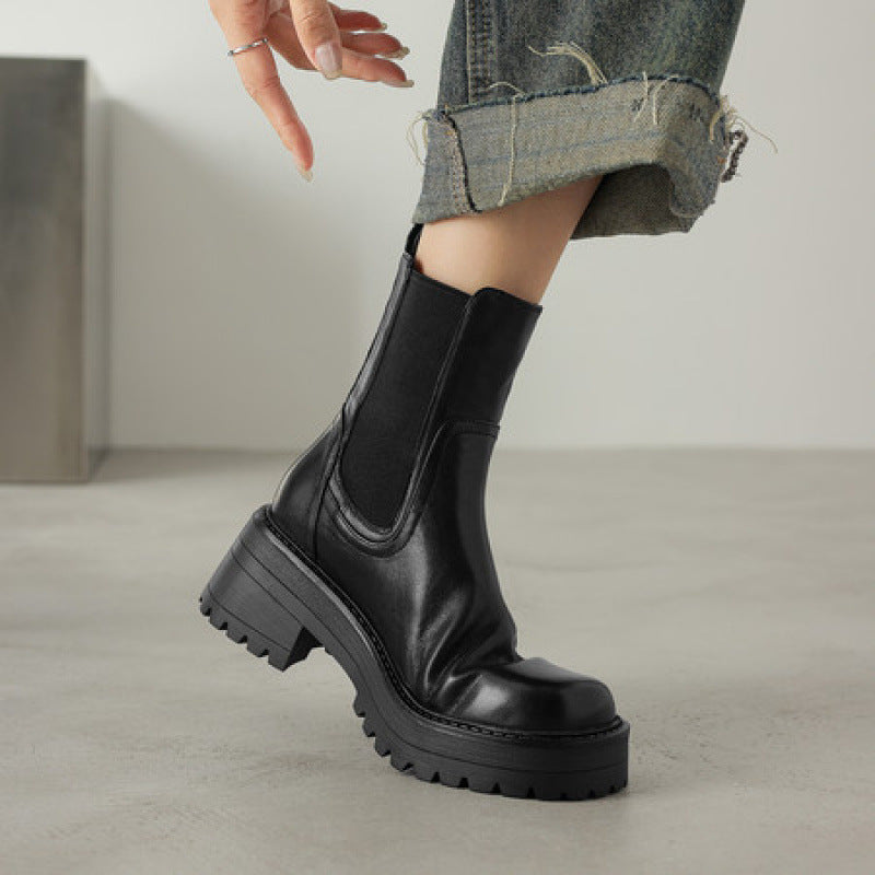 Black leather Chelsea boots with elastic side panels, chunky lug sole, round toe heel