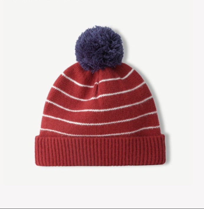 Red striped knit beanie with fluffy navy pom-pom and ribbed cuff