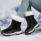 Black mid-calf zip-up snow boots with faux fur cuffs and lug sole.