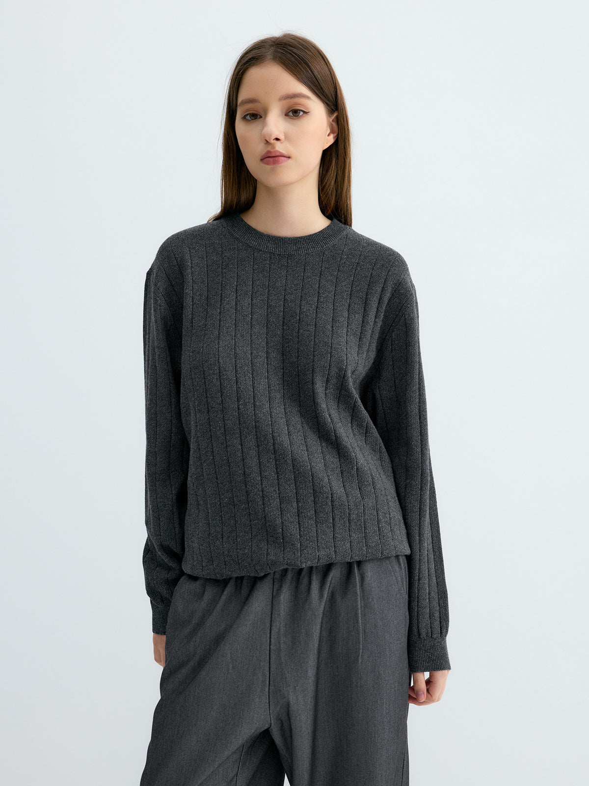 Dark gray ribbed crew neck sweater with wide knit ribs and banded cuffs