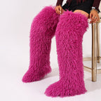 Hot pink shaggy faux fur thigh-high boots shown worn as a pair.
