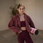 Women’s sherpa jacket in burgundy with snap front and stand collar; zip pockets