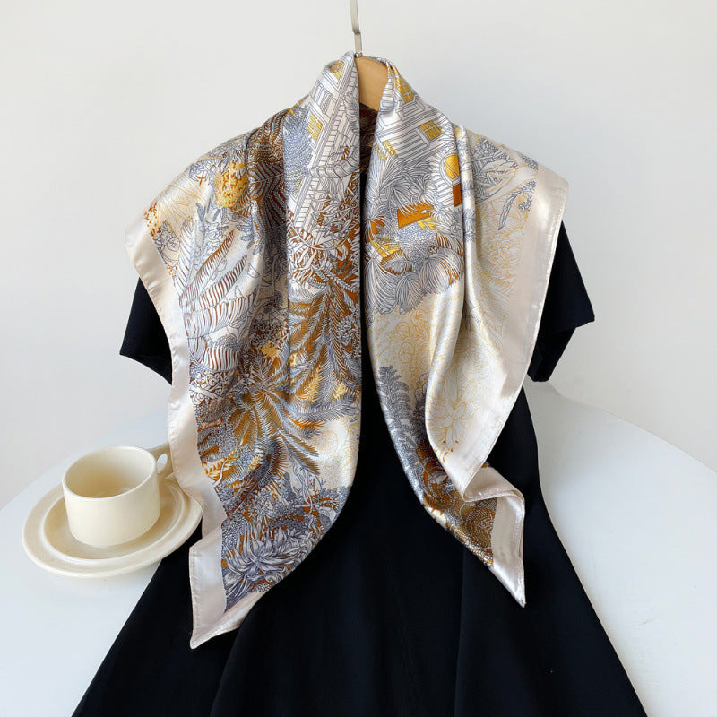 Camel and silver satin square scarf with tropical bird pattern, draped over black dress.