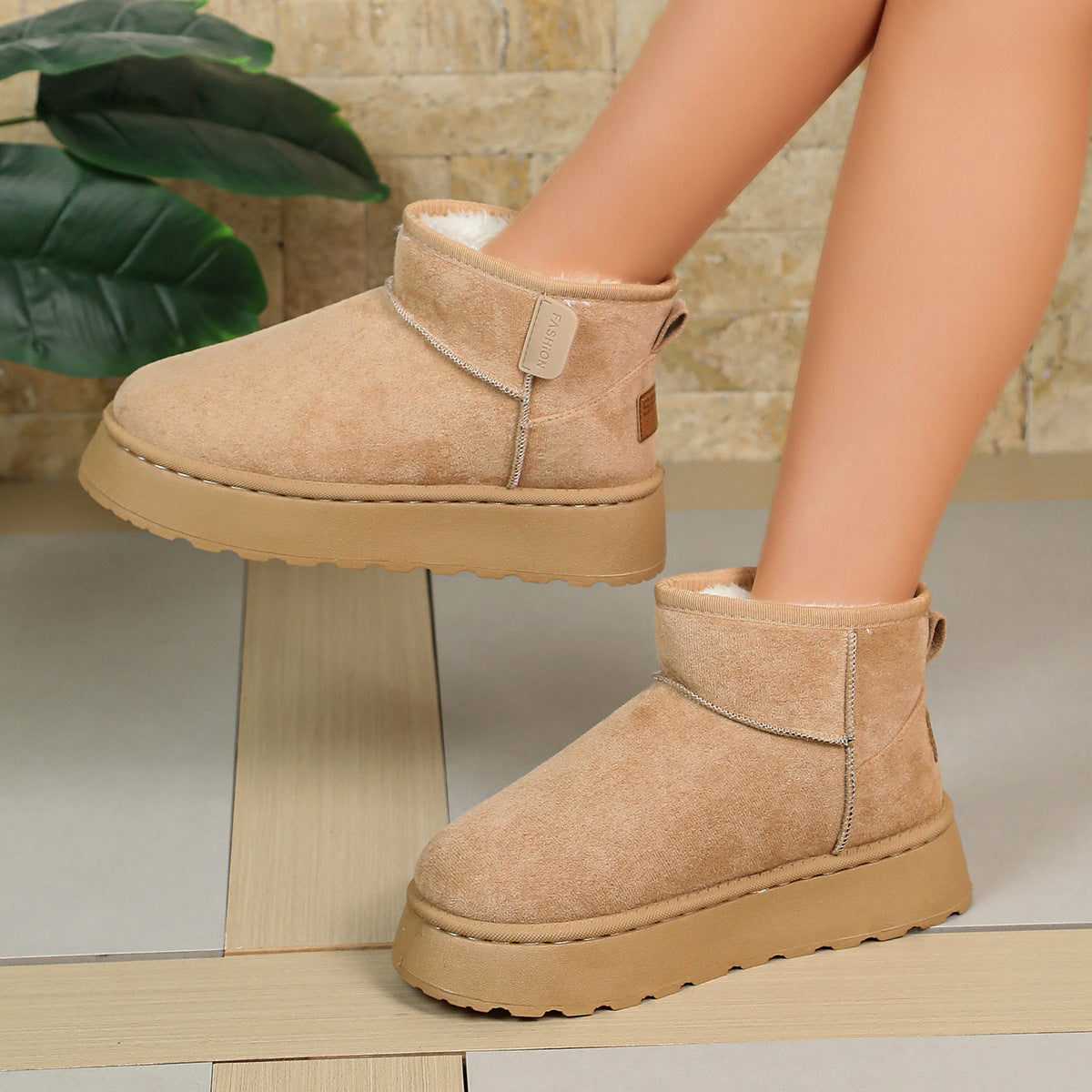 Women’s tan short snow boots with ankle strap, thick sole, and soft fleece lining