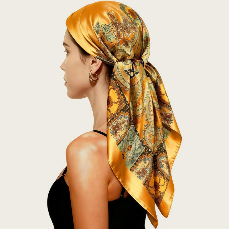 Satin head scarf in mustard satin with gold paisley print, tied at back.