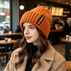 Chunky ribbed beanie in burnt orange with folded cuff and letter patch