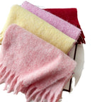 Oversized fuzzy scarf with fringe ends, folded; pink, yellow, and lavender sections visible