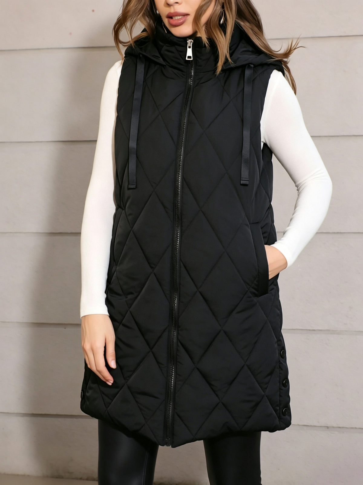 Black hooded quilted long puffer vest with front zipper and drawstring hood