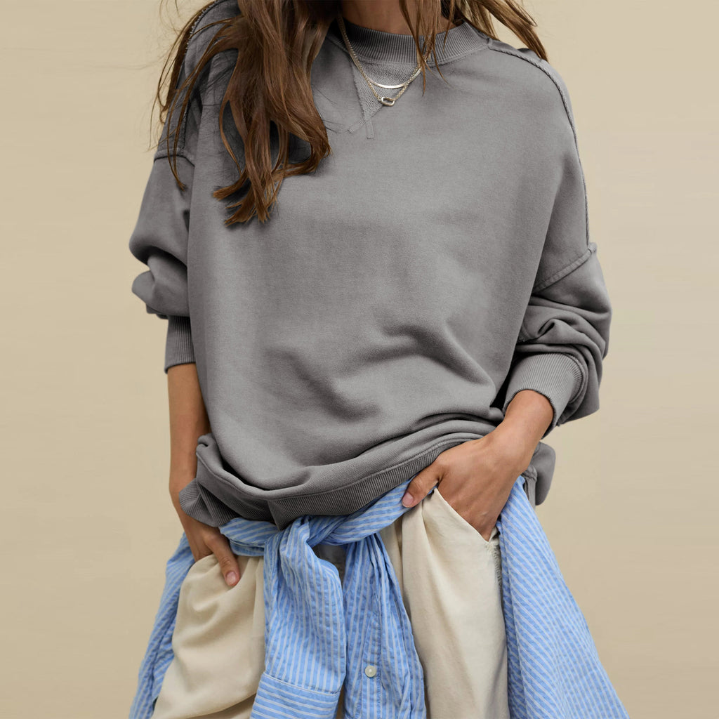Oversized crewneck sweatshirt in dark gray with visible seam lines and side slits
