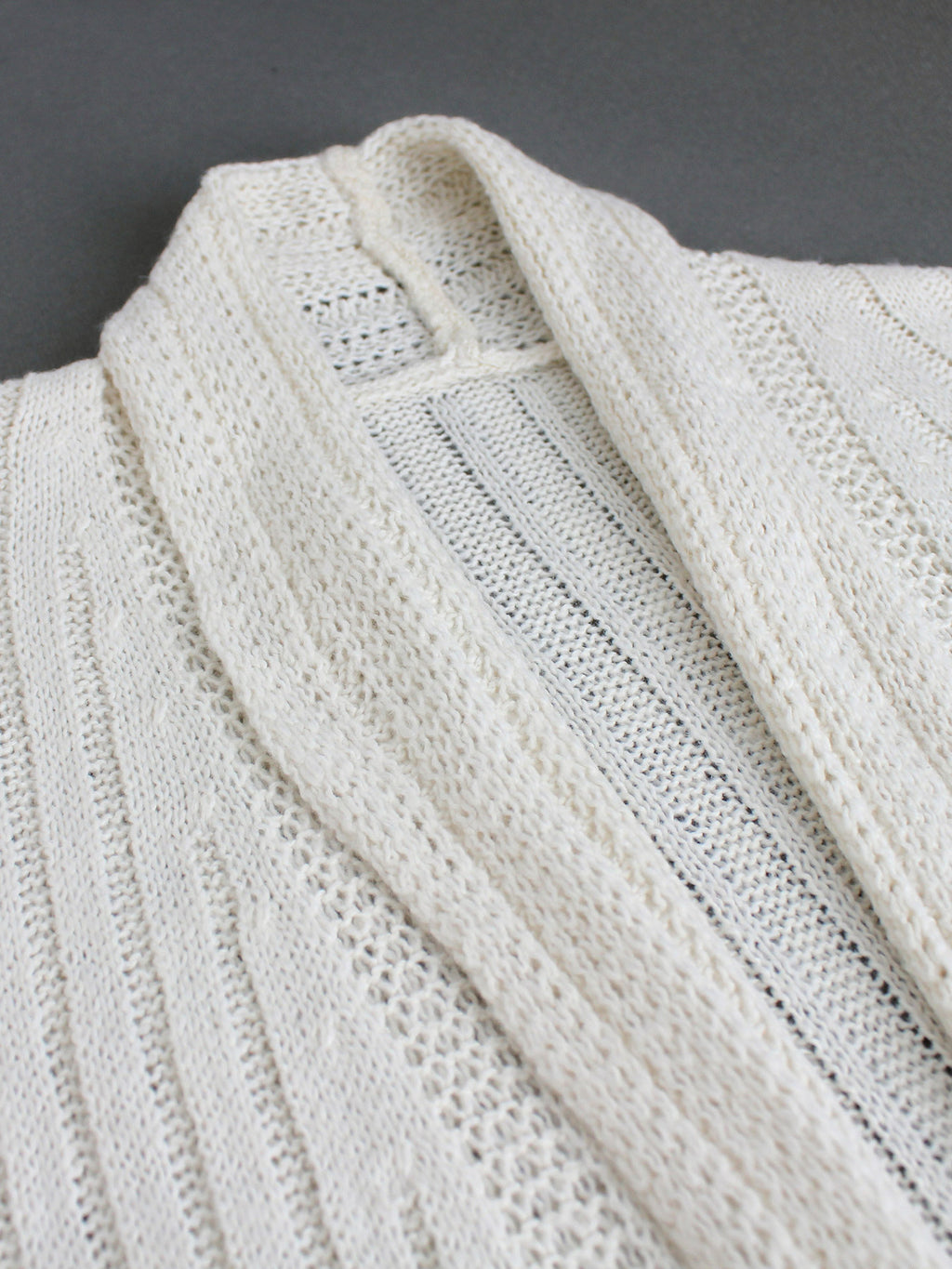 Off-white pointelle knit cardigan fabric detail, open-front drape panels