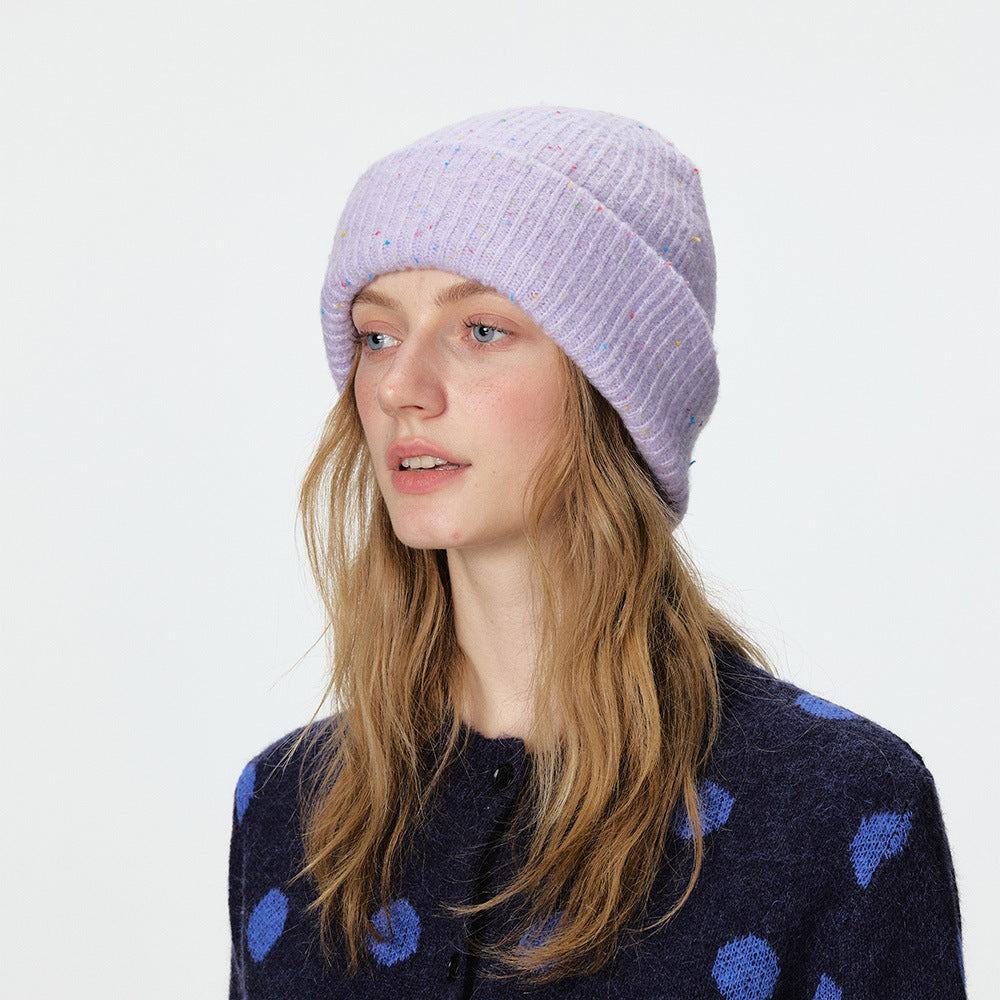 Speckled lavender rib-knit beanie with a wide folded cuff, worn on a model.