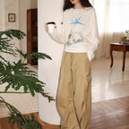 Cream long-sleeve graphic tee with blue star front print, crew neck, and cuffs