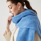 Oversized fuzzy mohair-blend scarf with fringe ends, sky blue, worn draped over shoulders