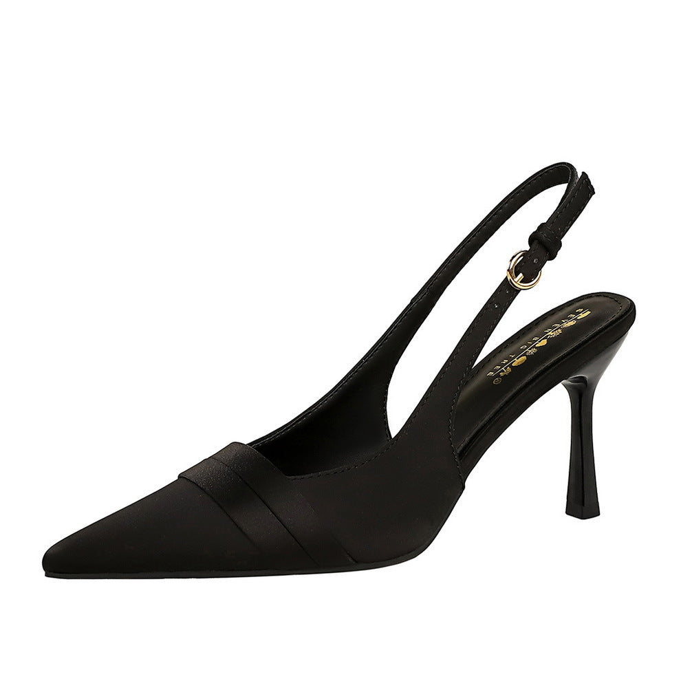 Black satin slingback pump with pointed toe, stiletto heel, and folded vamp band.