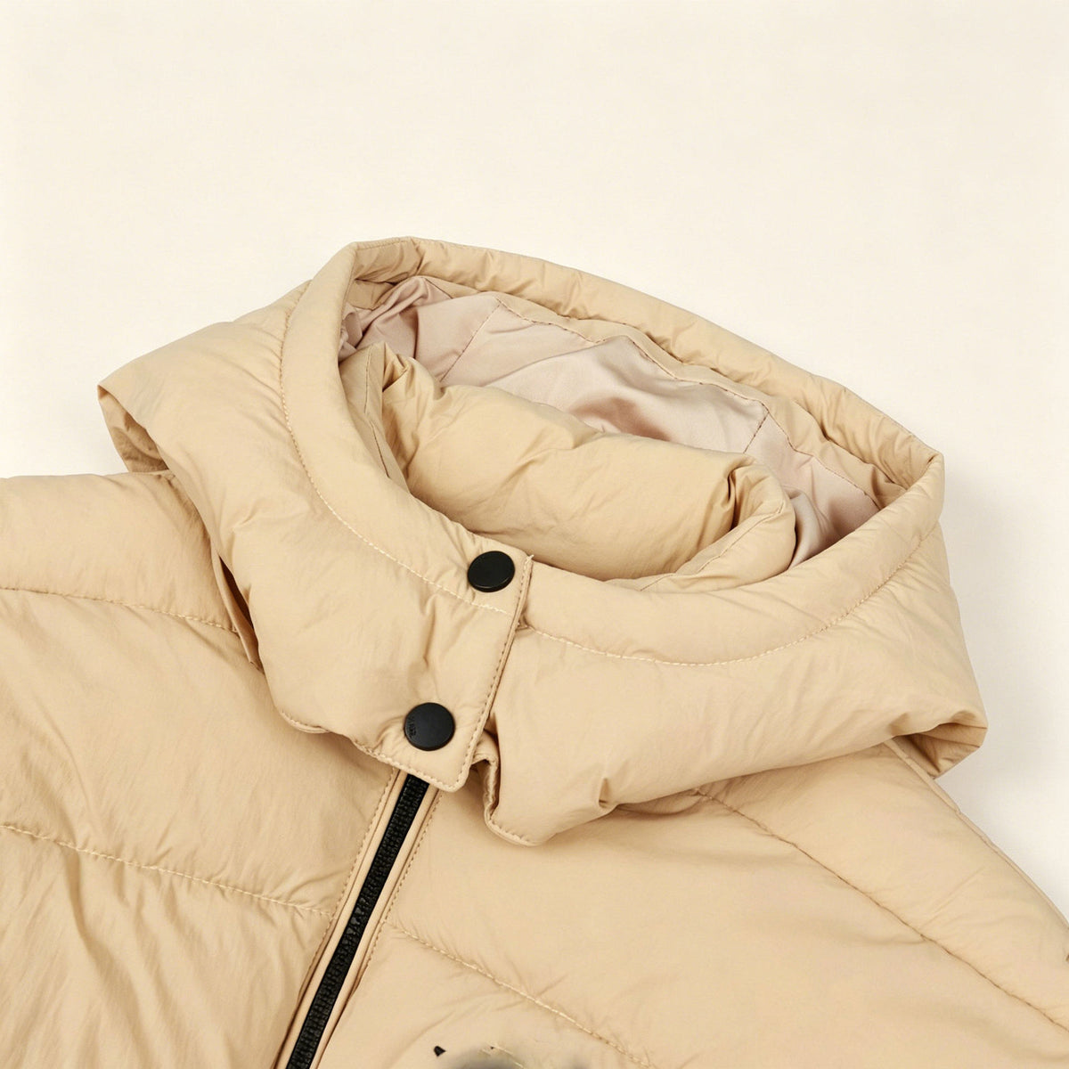 Khaki hooded puffer coat close-up with snap buttons and thick quilted padding